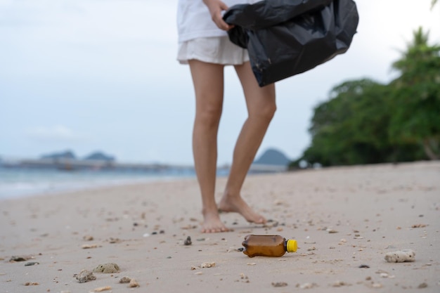 Red de oceaan Vrijwilligers halen afval op op het strand en plastic flessen zijn moeilijk te ontbinden