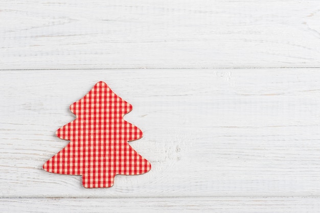 Red decorative fir tree on rustic white wooden table
