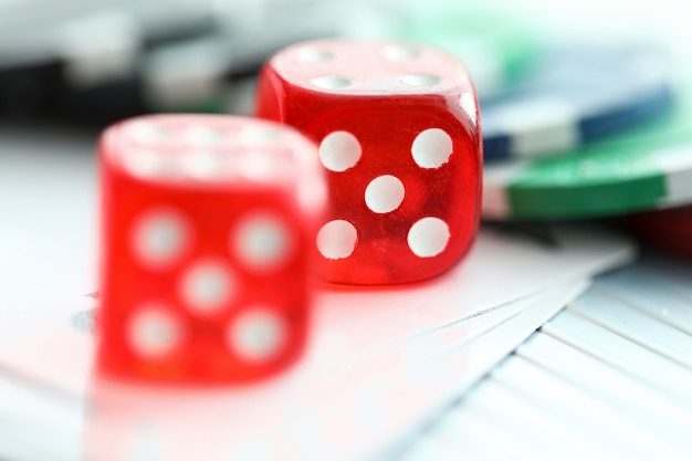 Red dices lying with casino chips as gambling symbol close-up