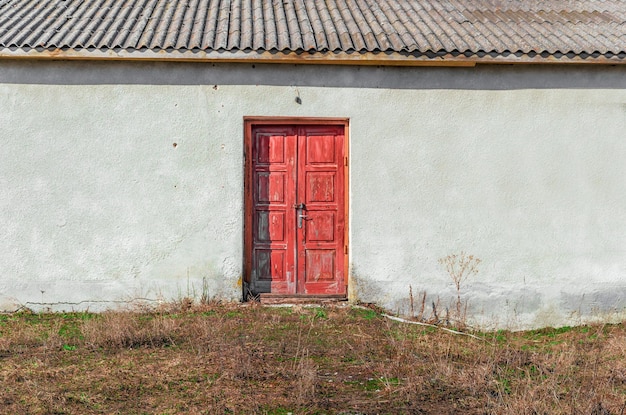 Red door closed with a padlock in an old abandoned building