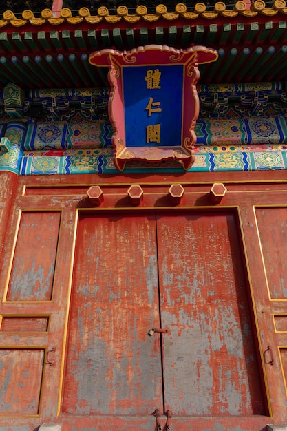 Красная дверь с табличкой над ней, на которой написано "китайское слово".