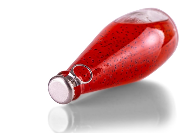 Red drinks with basil seeds or falooda seeds or tukmaria in bottles on white background