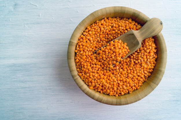 Red dry lentils in a bamboo bowl.