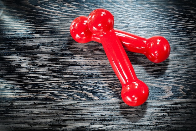 Red dumbbell weights on vintage wooden board