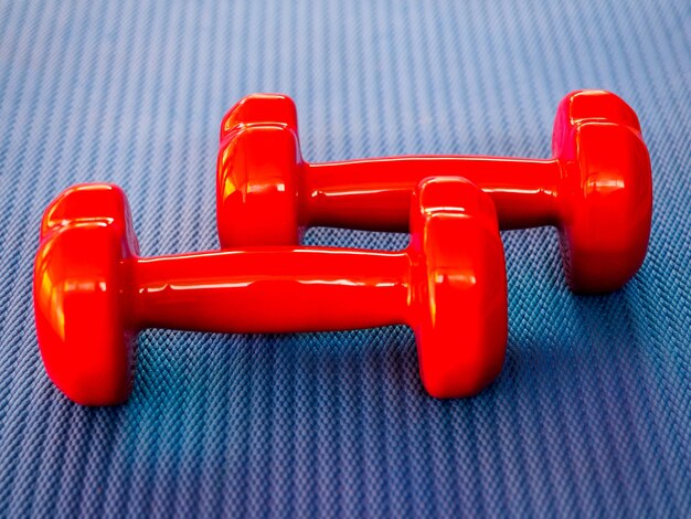 Red dumbbells on a fitness mat