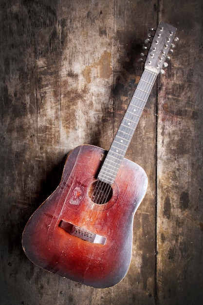 Red dusty guitar on a wooden table