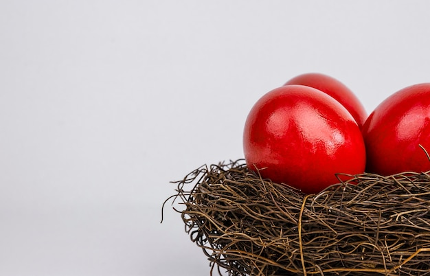 Photo red easter eggs in a nest on a gray background