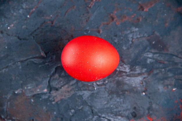 Red egg on dark mix colors distressed background with free space