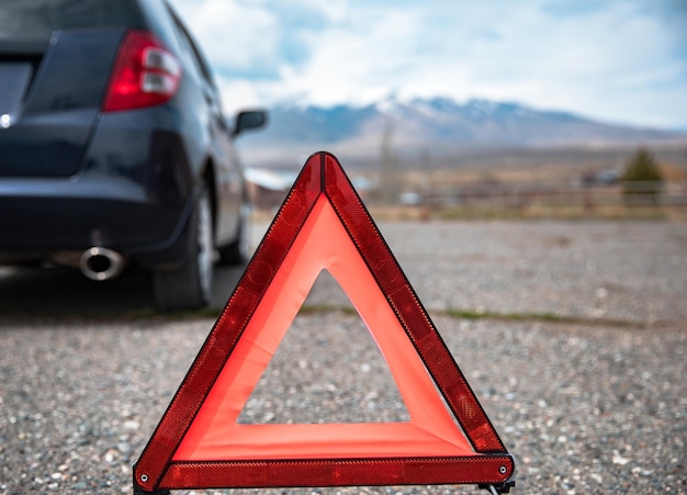 Red emergency stop sign and broken car