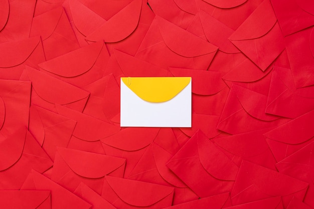 Фото Красный фон конверта с белой карточкой с желтой деталью в центре, с местом для текста.