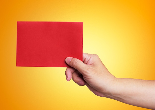 Red envelope in the hand isolated on orange background