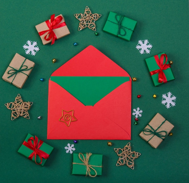Красный конверт со звездой в рамке из подарков и звезд на зеленом фоне
