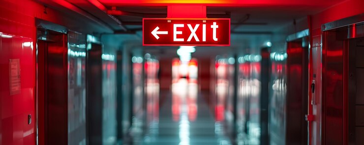 Photo a red exit sign with an arrow pointing to exit