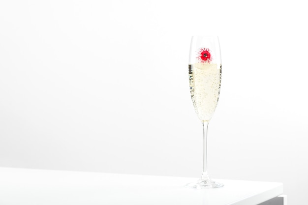 Red eye in a champagne glass with on white background elegant halloween decor autumn holiday concept