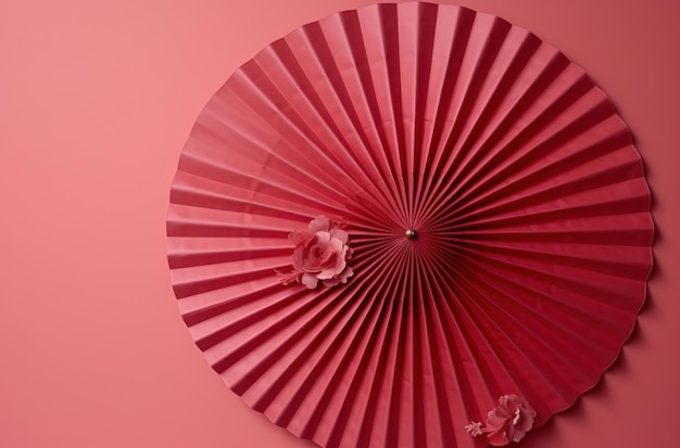 a red fan is hung from a pink wall