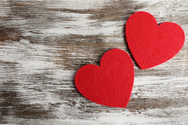 Red felt hearts on grey wooden background