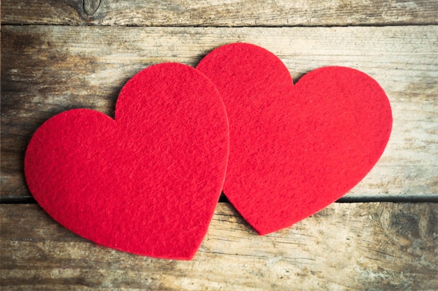 Red felt hearts on wooden background