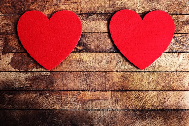 Red felt hearts on wooden background