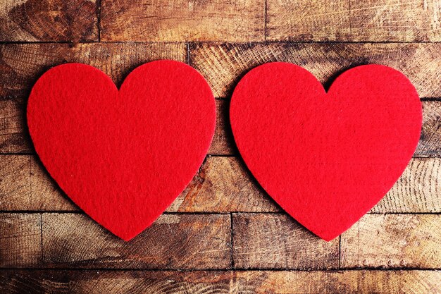 Red felt hearts on wooden background