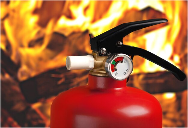 Red fire extinguisher and flames, close-up view