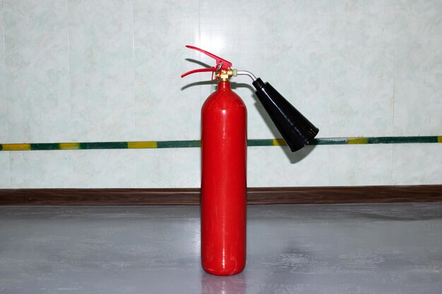 Red fire extinguisher in the room closeup