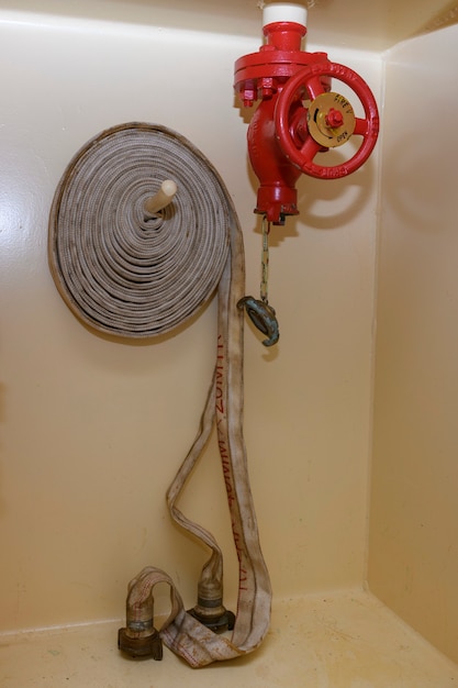 Red fire hydrant with coiled hose. Fire fighting equipment.