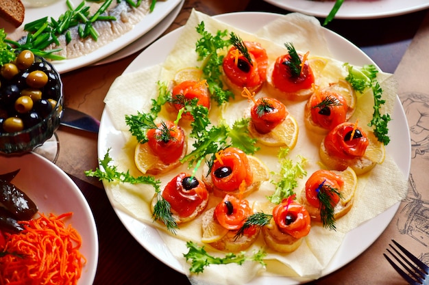 Red fish sandwiches on a plate.