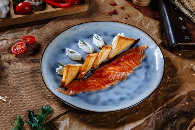 Foto pesce rosso con pane fritto e fette di panna acida