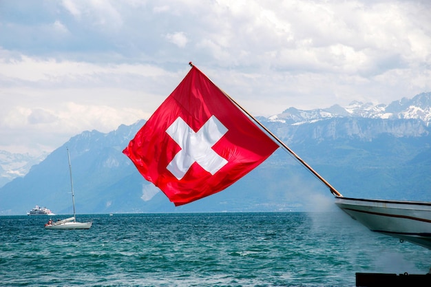 Red flag on lake against sky