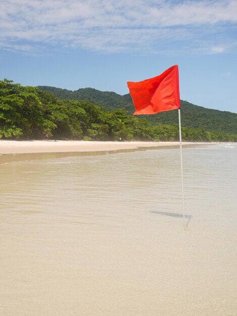 Red flag on a tropical island beach