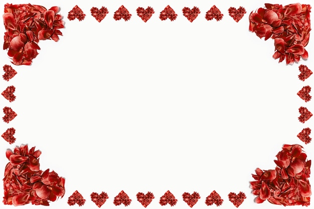 Red flower petals in shape of hearts on white surface