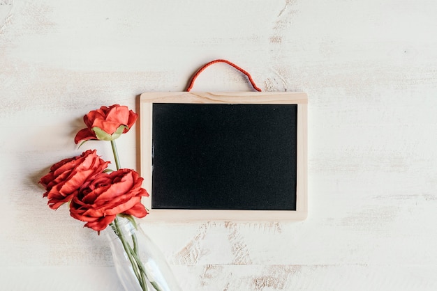 Photo red flowers with blackboard