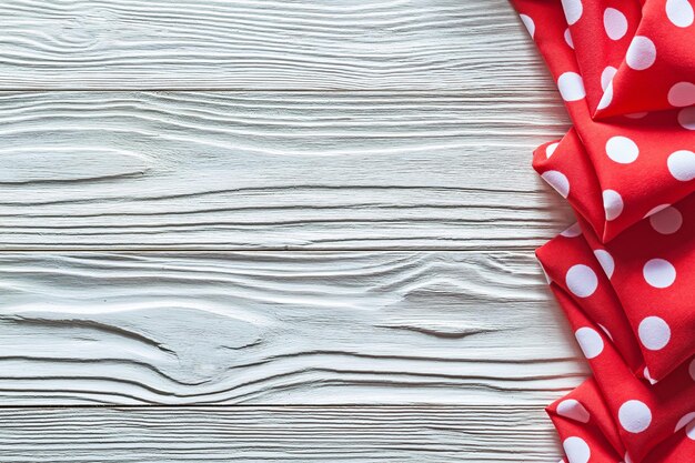 Red folded polkadot tablecloth on wood board copy space