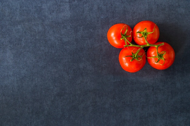 Red four tomatoes on the blue table, vegetable