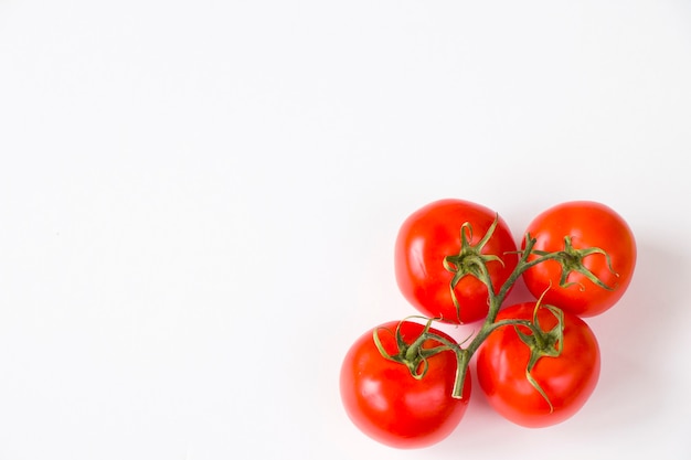 Rosso quattro pomodori sul tavolo bianco, verdura