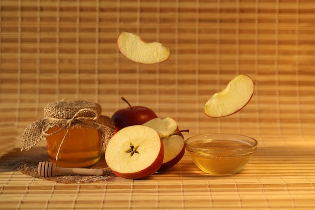 Red fresh apples with honey on wooden background with copy space. apple feast