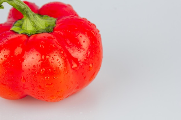 Red fresh bell pepper paprika isolated with water drops on white background Fresh ripe colorful bell pepper as a background close up