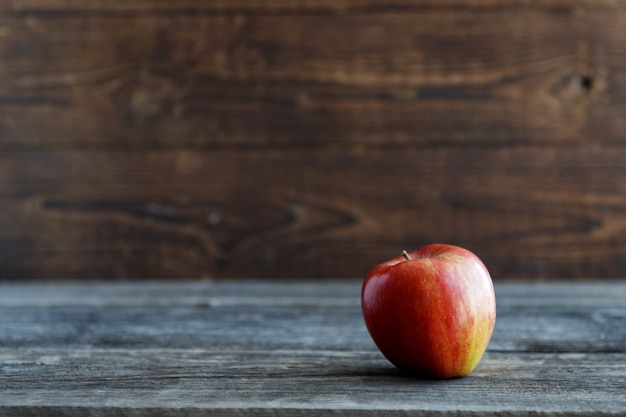 Red fresh bio apple on a wooden rustic table. Wood background background.