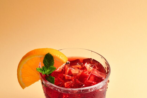 氷、グレープフルーツ、ベージュの背景にミントと赤の新鮮な飲み物。テキストまたはデザインのためのスペース。