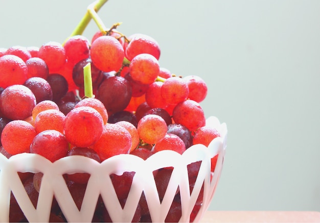 Red fresh grapes on white basket