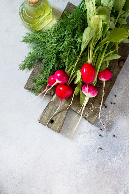 Red fresh radishes and dill with oil