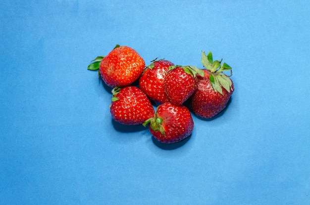 Red fresh strawberries on a blue background