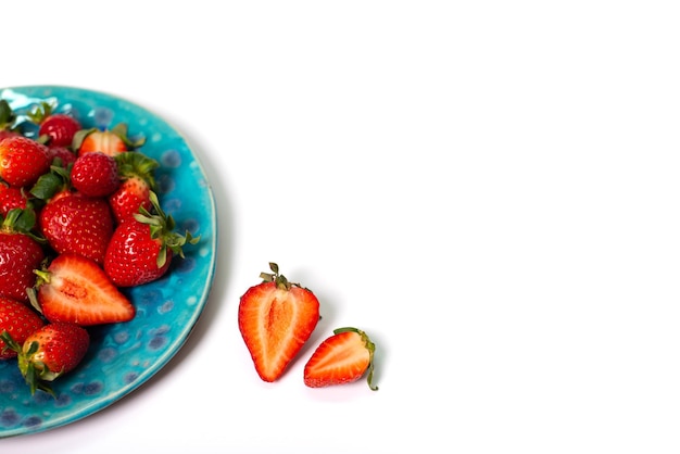 Photo red fresh strawberries in a blue ceramic plate on a white background strawberry closeup