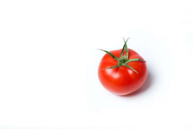 Red fresh tomato on a white surface