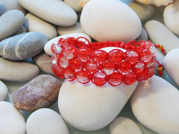 Red friendship bracelet and sea stones