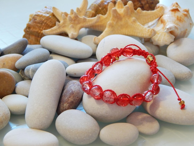 Red friendship bracelet on stones