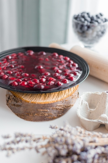 Gelatina di frutta rossa in ciotola, marmellata di ciliegie conservata fatta in casa in banda nera, stile rustico