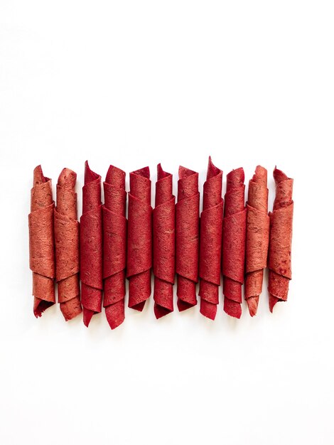 Red fruit leather rolls isolated on white