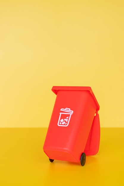 Photo red garbage container on yellow background