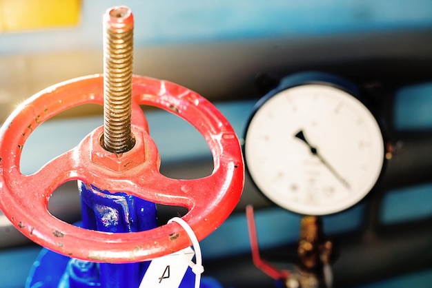 Red gas valve and pressure gauge with an arrow on the limit Background for gasification